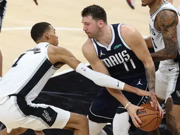 Victor Wembanyama trata de robar el balón a Luka Doncic Victor Wembanyama trata de robar el balón a Luka Doncic