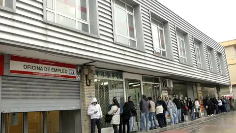 Una cola de personas frente a una oficina de empleo Una cola de personas frente a una oficina de empleo