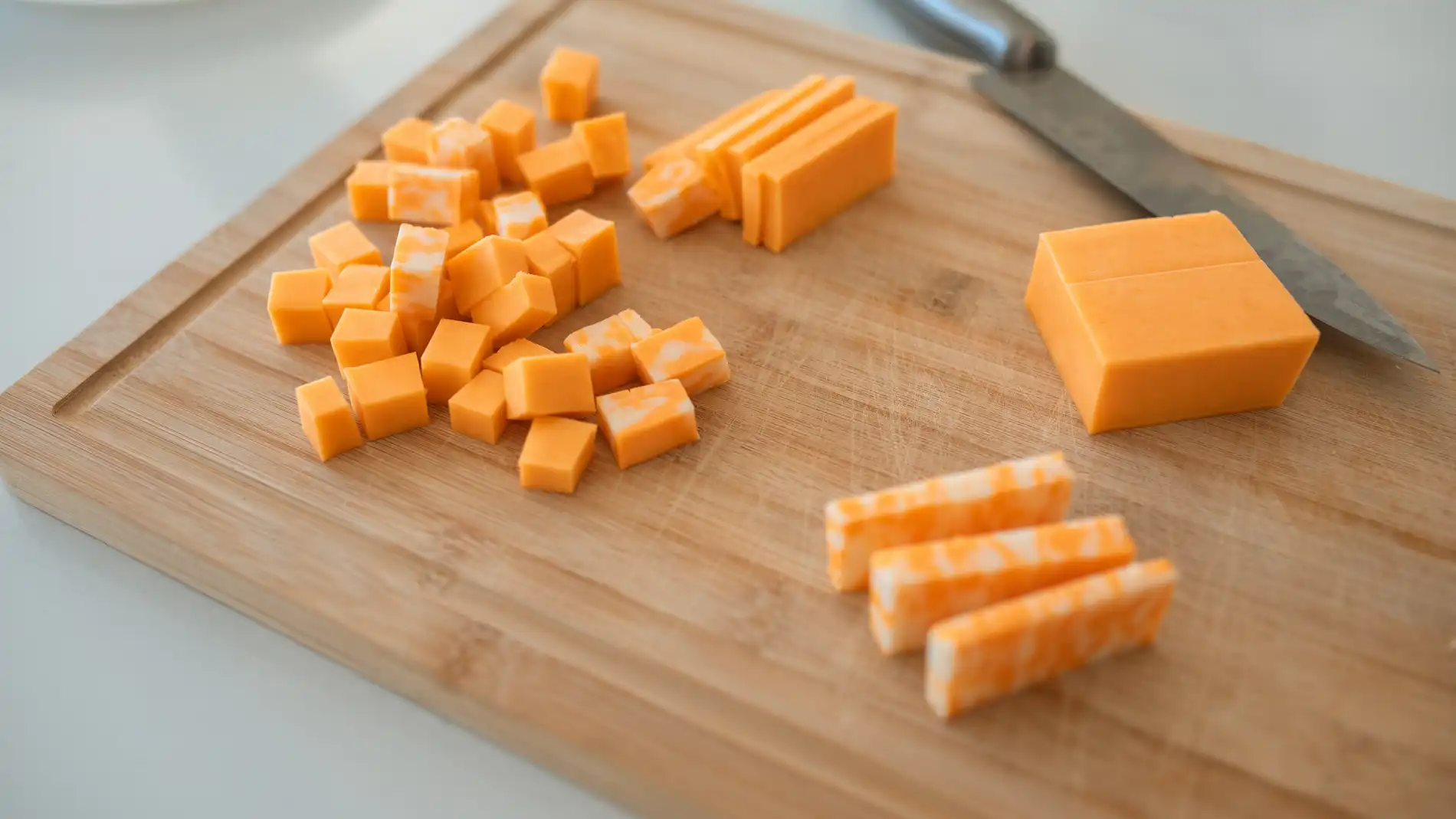 Cuchillo, tabla y tacos de queso