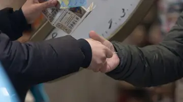 Una persona compra Lotería de Navidad, en Madrid (España).