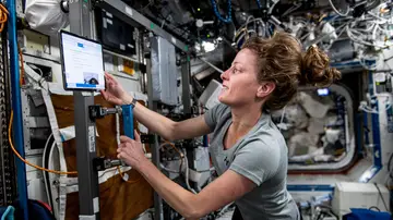 La astronauta de la NASA e ingeniera de vuelo de la Expedición 70, Loral O'Hara, prepara una bicicleta de ejercicios para una sesión de ejercicios dentro del módulo de laboratorio Destiny a bordo de la Estación Espacial Internacional.