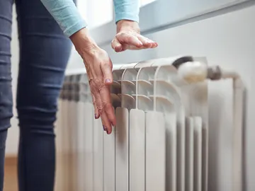Una mujer prueba un radiador Una mujer prueba un radiador