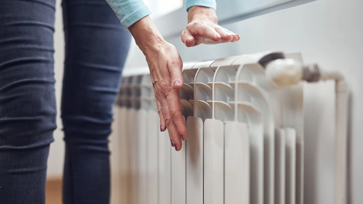 Una mujer prueba un radiador Una mujer prueba un radiador