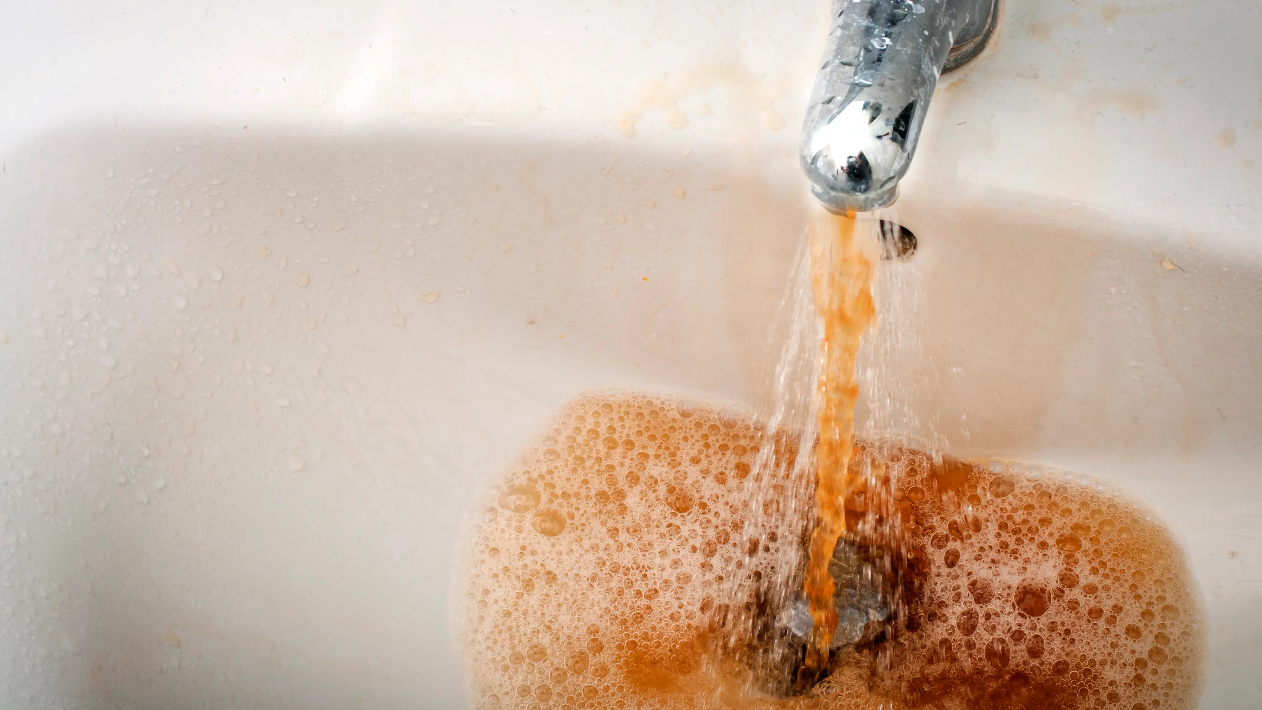 Imagen de archivo de agua sucia saliendo de un grifo Imagen de archivo de agua sucia saliendo de un grifo