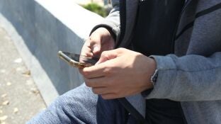 Un hombre con un tel&eacute;fono m&oacute;vil