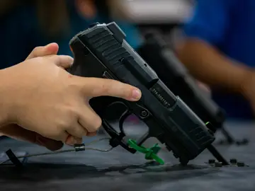 Un niño sujeta un arma Un niño sujeta un arma