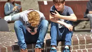 Dos niños mirando el móvil La forma del cerebro cambia en los niños por el uso de las pantallas