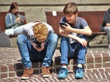 Dos niños mirando el móvil