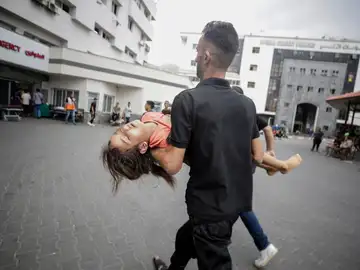 Foto de archivo de un hombre que carga a un herido en el hospital Al Shifa de la ciudad de Gaza Foto de archivo de un hombre que carga a un herido en el hospital Al Shifa de la ciudad de Gaza