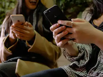 Jóvenes mirando sus teléfonos móviles