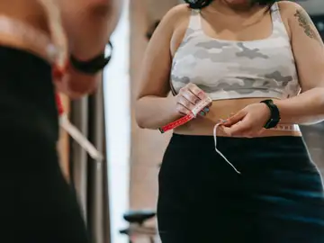 Una chica adolescente se mide la cintura Una chica adolescente se mide la cintura