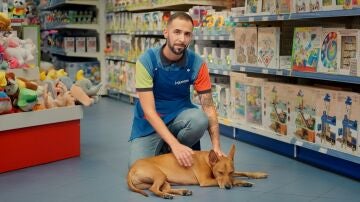 El dueño de un perro en una tienda de juguetes