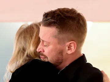 Macaulay Culkin fundiéndose en un abrazo con Catherine O'Hara Macaulay Culkin fundiéndose en un abrazo con Catherine O'Hara