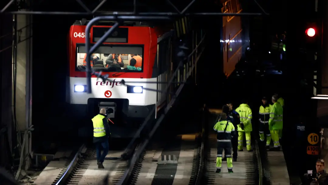Operarios junto al tren que ha descarrilado