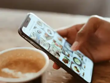 Una persona desliza su teléfono móvil Una persona desliza su teléfono móvil