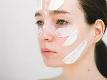 Una mujer con crema en la cara Una mujer con crema en la cara