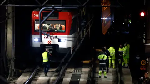 Varios operarios junto a un tren de Cercanías que ha descarrilado Varios operarios junto a un tren de Cercanías que ha descarrilado