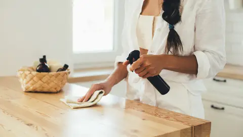 Una mujer limpiando la encimera de la cocina Una mujer limpiando la encimera de la cocina