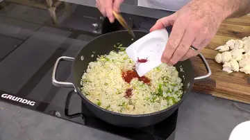 Agrega arroz, el pimentón, el azafrán y la salsa de tomate