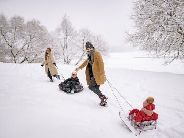 Familia con trineos en la nieve