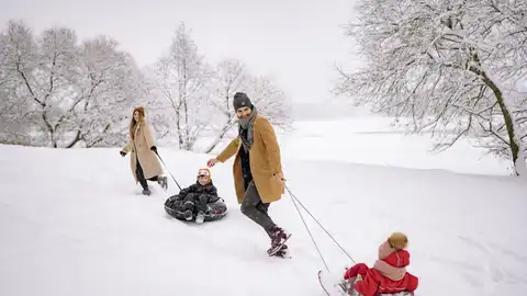 Familia con trineos en la nieve Familia con trineos en la nieve