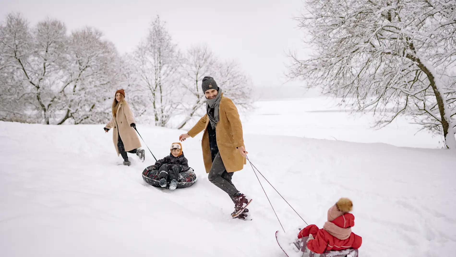 Familia con trineos en la nieve