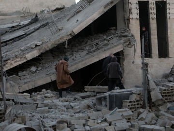 Palestinos revisan un edificio derrumbado por los ataques israelíes