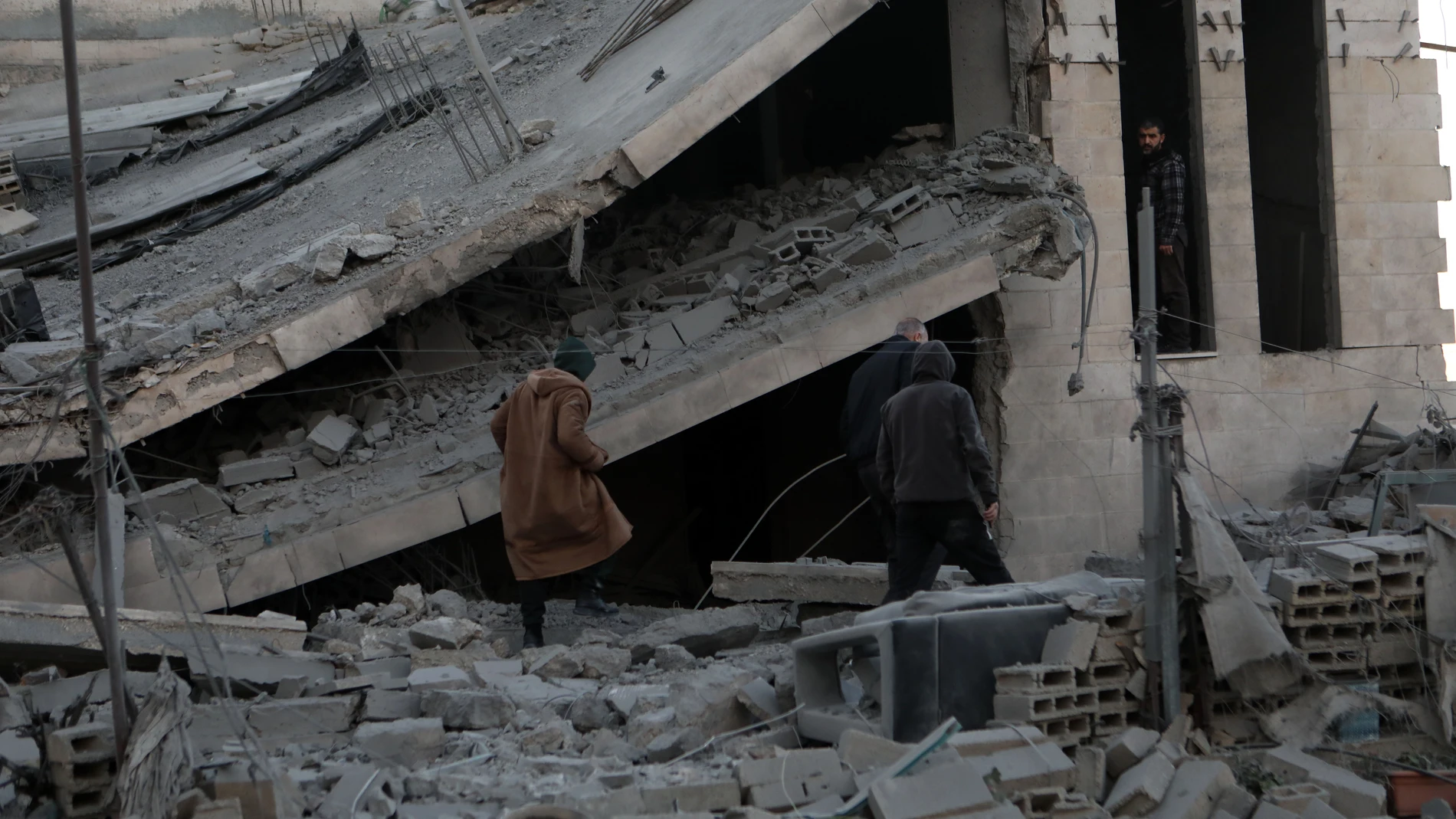 Palestinos revisan un edificio derrumbado por los ataques israelíes