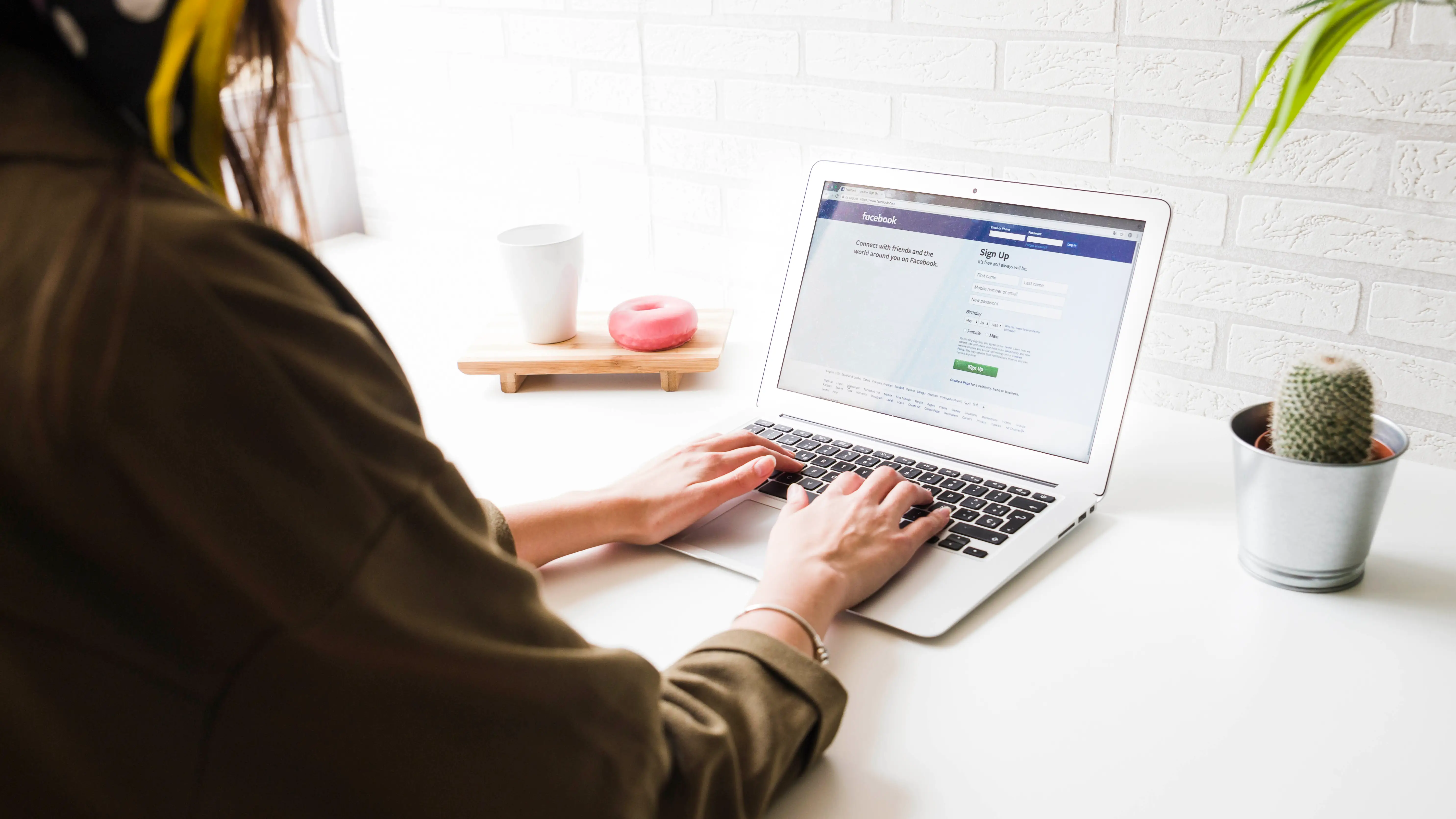 Una mujer iniciando sesión en Facebook Una mujer iniciando sesión en Facebook