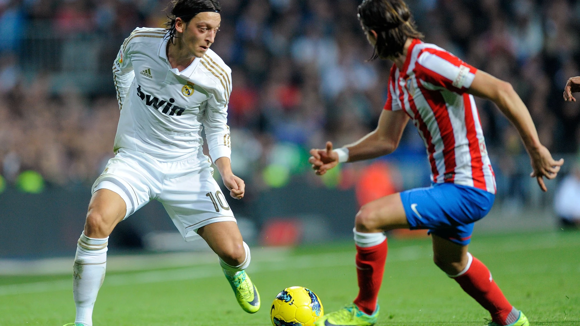 Mesut Özil controla un balón ante Filipe Luis en un Real Madrid - Atlético 