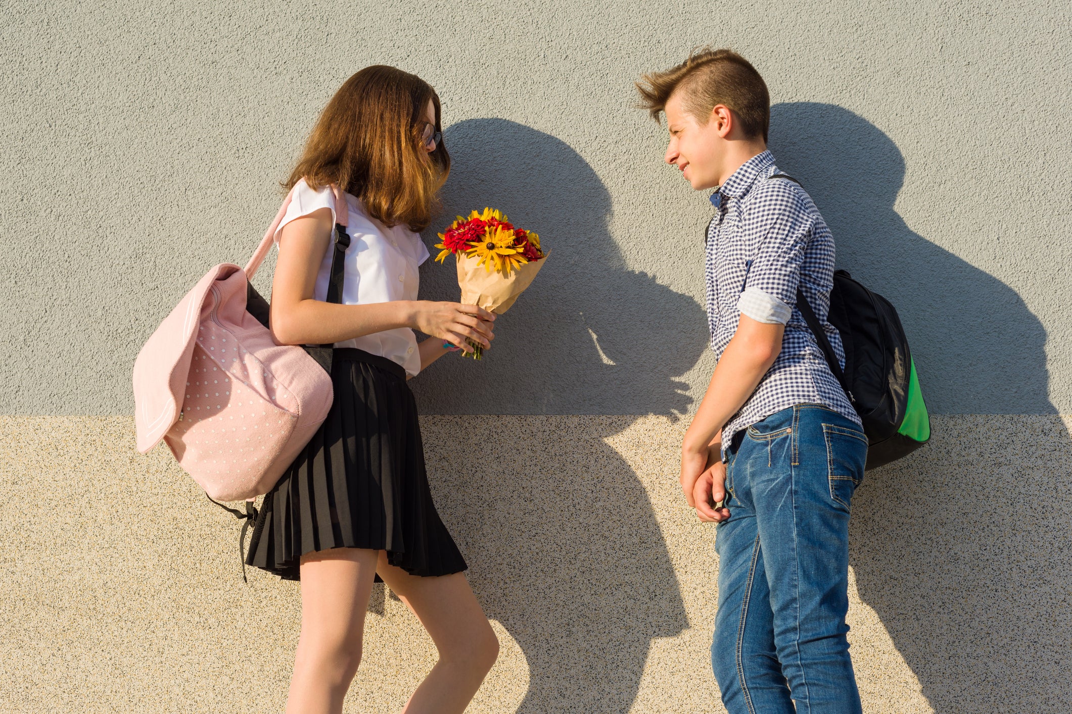 Девчонка дает пацану. Первое свидание подростков. Подросток дарит девочке цветы.