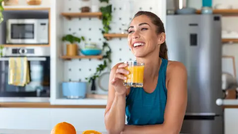 Mujer tomándose un zumo de naranja