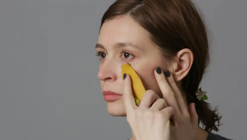 Mujer aplicándose plátano en la cara