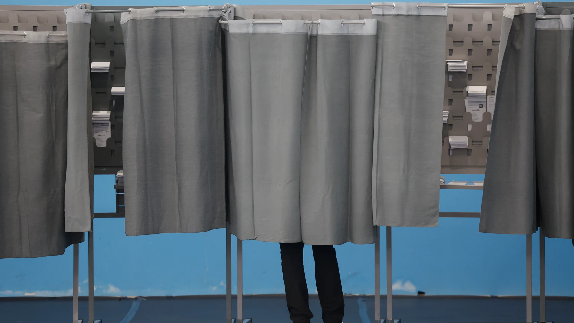 Un hombre utiliza una cabina de votación en el colegio Ames a las afueras de Santiago de Compostela