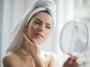 Una mujer se mira al espejo Una mujer se mira al espejo