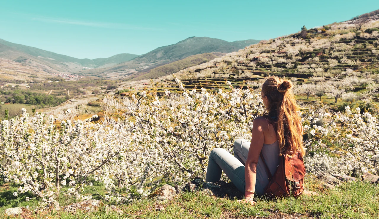Chica joven viendo los cerezos en flor en el Valle del Jerte