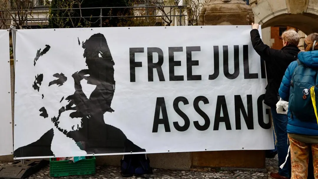 Manifestante sujeta una pancarta con el retrato de Julian Assange Manifestante sujeta una pancarta con el retrato de Julian Assange