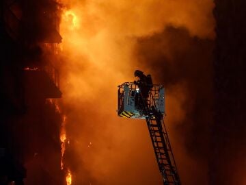 Un bombero tratando de apagar el incendio del edificio de Valencia