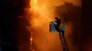 Un bombero tratando de apagar el incendio del edificio de Valencia