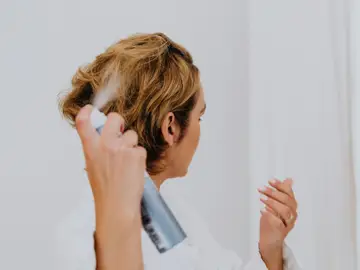 Mujer con un spray para el pelo Mujer con un spray para el pelo