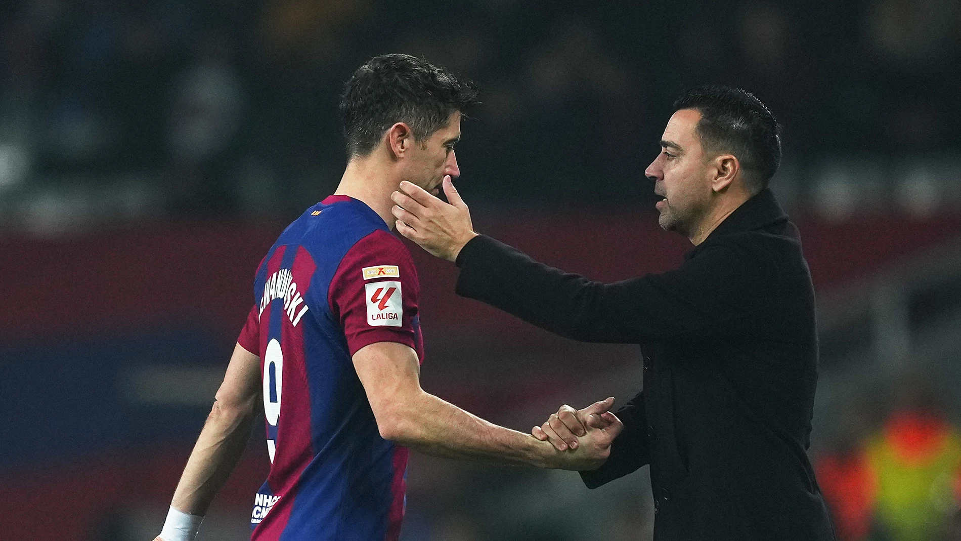 Xavi Hernández se saluda con Robert Lewandowski en un partido del FC Barcelona esta temporada