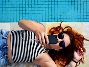 Descansando en la piscina con el móvil
