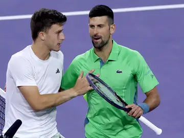 Luca Nardi charla con Djokovic tras el partido