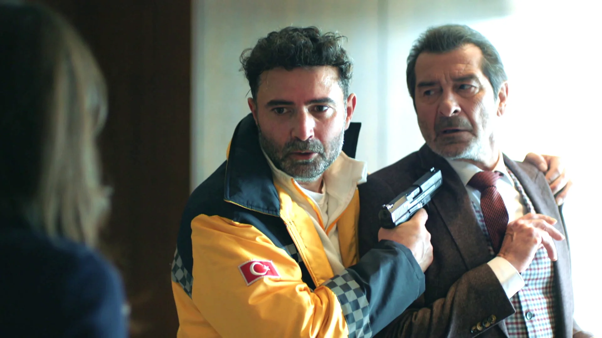 Okan apunta a Yekta con un arma