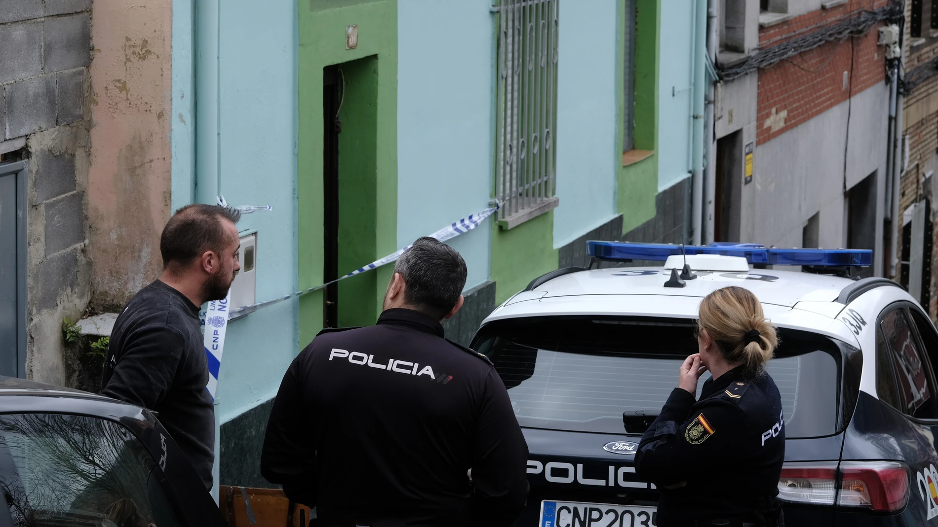 Unos agentes de la Policía Nacional hablan este sábado con un vecino de la localidad de La Felguera, en el municipio de Langreo 