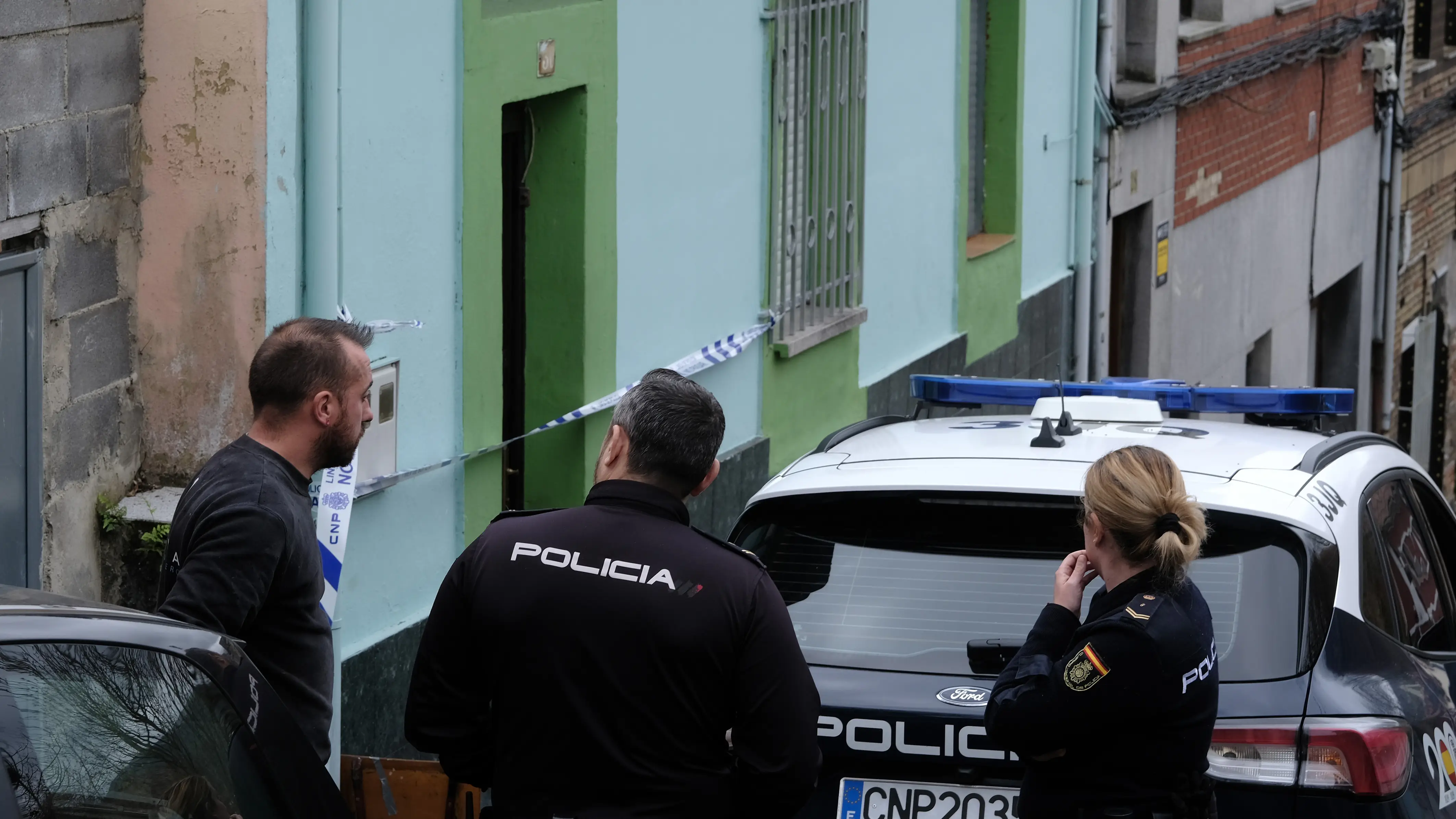 Unos agentes de la Polic&iacute;a Nacional hablan este s&aacute;bado con un vecino de la localidad de La Felguera, en el municipio de Langreo 