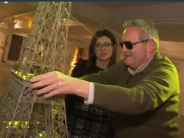 Imagen de una persona con dispacidad visual tocando una maqueta de la Torre Eiffel