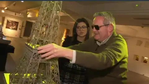 Imagen de una persona con dispacidad visual tocando una maqueta de la Torre Eiffel Imagen de una persona con dispacidad visual tocando una maqueta de la Torre Eiffel