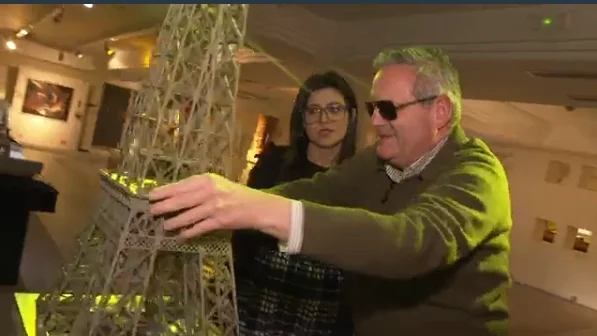 Imagen de una persona con dispacidad visual tocando una maqueta de la Torre Eiffel Imagen de una persona con dispacidad visual tocando una maqueta de la Torre Eiffel