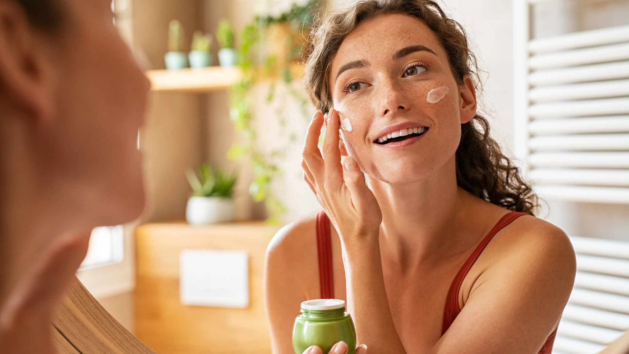 Mujer aplicándose crema en la cara Mujer aplicándose crema en la cara